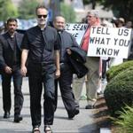 Unidentified priests passed protesters Tuesday as they headed toward the meeting at St. Julia?s Parish in Weston. 