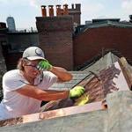 Christian Follett wiped his forehead to keep his eyes clear of sweat while working on a copper/rubber roof on Beacon Hill.