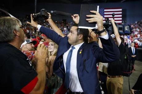 A staff member for President Donald Trump blocked a camera as a photojournalist attempted to take a photo of a protester during a campaign rally in Evansville, Indiana. 
