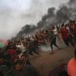 Protesters run to cover from teargas fired by Israeli troops, while others burn tires near fence of the Gaza Strip border with Israel, during a protest east of Gaza City, Friday, Aug. 31, 2018. Gaza's Health Ministry says Israeli gunfire wounded about 80 Palestinians at a weekly protest along the border with Israel. (AP Photo/Adel Hana)