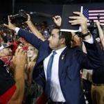 A staff member for President Donald Trump blocked a camera as a photojournalist attempted to take a photo of a protester during a campaign rally in Evansville, Indiana. 