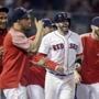 Boston Red Sox's J.D. Martinez, second from right, celebrates with teammates after scoring after Eduardo Nunez reached first base on a throwing error, breaking a 7-7 tie, during the bottom of the ninth inning of a baseball game at Fenway Park in Boston, Tuesday, Aug. 28, 2018. The Red Sox won 8-7. (AP Photo/Charles Krupa)