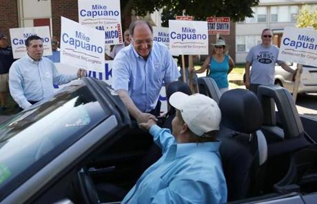 Representative Mike Capuano leaned over to shake hands with Jeanne Cristiano of Everett as she drove past a polling place in Everett. 

