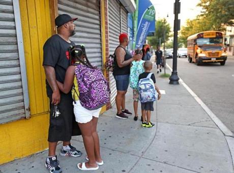 Parents waited with their children for a bus that was running late on Geneva Avenue on Thursday.
