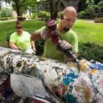 Pam Norgustin and Josh Brown of Warren J. Nordin & Son painting company stripped thick layers of paint from the cannon at Tufts University. The cannon was stripped down to the base for the first time in decades.