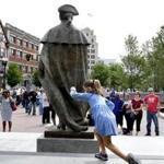 A young girl played behind the newly unveiled statue of John Hancock in Quincy on Saturday.