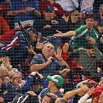 Boston, MA: 9-12-18: A fan seated on the thirdbase line was hit in the head by a bat that slipped out of the hands of the Blue Jays Devon Travis in the top of the eighth inning. His hat was knockd off and he went ddown, but a few he was up and giving the thumbs up sign to cheering fans around him. The Boston Red Sox hosted the Toronto Blue Jays in a regular season MLB baseball game at Fenway Park. (Jim Davis/Globe Staff) 