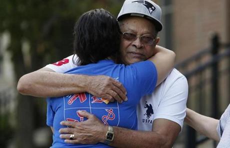 The father of Leonel Rondon is embraced outside of the family's home in Lawrence. Rondon was killed yesterday when a chimney from a house explosion landed on his car.
