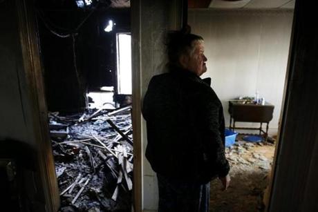Brenda Jones leaned against the wall outside her bedroom that was covered in debris after a fire in her Lawrence home. 
