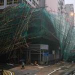 A woman walked past collapsed bamboo scaffolding hanging from a building during Super Typhoon Mangkhut, which rocked Hong Kong on Sept. 16 en route to southern China, injuring scores and sending skyscrapers swaying, after killing at least 30 people in the Philippines.