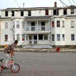 A bicyclist rode past a multi-family home on Springfield Street in Lawrence Friday.