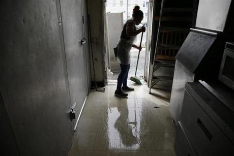 Lawrence, MA--9/17/2018-- Ana Gonzalez swept water off of the floor that had melted from the frozen items in the freezer at Carleen's Coffee Shoppe in South Lawrence. (Jessica Rinaldi/Globe Staff) Topic: 18lawrence Reporter: 

