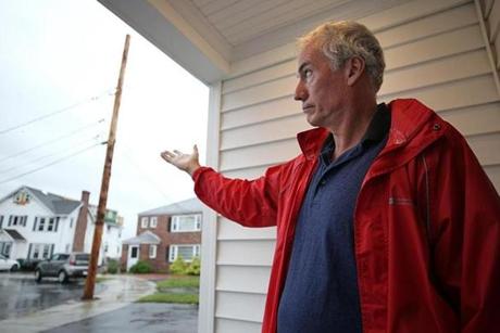 Watertown, MA., 09/12/18, Jack Keating is upset that a truck using an overhead boom to deliver building materials to a neighbor's house pulled down the overhead wires and ripped the electrical service off his house. Suzanne Kreiter/Globe staff 
