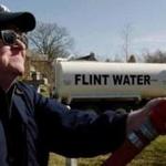 Michael Moore sprays water from Flint, Mich., on the governor?s lawn in ?Fahrenheit 11/9.?