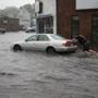 A man pushed a car on Independence Avenue in Quincy, after the street was flooded by heavy rain earlier this month.  