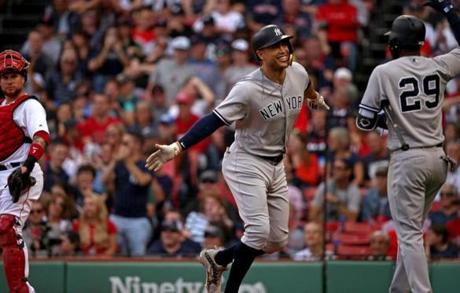Boston, MA - 9/29/2018 - (7th inning) New York Yankees designated hitter Giancarlo Stanton (27) celebrates his solo home run off Boston Red Sox starting pitcher Steven Wright (35) with New York Yankees Adeiny Hechavarria (29) during the seventh inning. The Boston Red Sox host the New York Yankees in Game 2 of a three game series at Fenway Park. - (Barry Chin/Globe Staff), Section: Sports, Reporter: Peter Abraham, Topic: 30Red Sox-Yankees, LOID: 8.4.3290523935.
