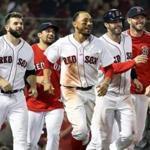 Boston, MA: 8-28-18: Following the game winning run scoring on a throwing error, the Red Sox (left to right) Mitch Moreland Nathan Eovaldi, Mookie Betts, J.D. Martinez (who scored the winning run) and Chris Sale are all smiles as thy head to celebrate with teammate Eduardo Nunez, who was safe at first base on the play. The Boston Red Sox hosted the Miami Marlins in a regular season inter league MLB baseball game at Fenway Park. (Jim Davis/Globe Staff) 