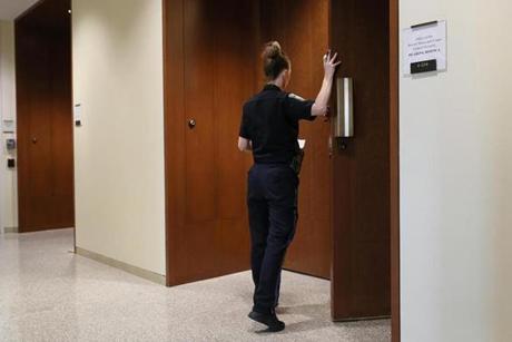 An officer guarded the door during a show cause hearing in Boston.
