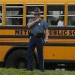 A state trooper worked the scene near a bus filled with evacuated students. 