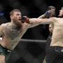 Conor McGregor, left, and Khabib Nurmagomedov throw punches during a lightweight title mixed martial arts bout at UFC 229 in Las Vegas, Saturday, Oct. 6, 2018. (AP Photo/John Locher)