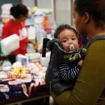 A woman and her 3-month-old child collected donated items a relief center in Lawrence last month.