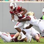 RALEIGH, NC - OCTOBER 06: Taj-Amir Torres #24 of the Boston College Eagles tackles Ricky Person Jr. #20 of the North Carolina State Wolfpack during their game at Carter-Finley Stadium on October 6, 2018 in Raleigh, North Carolina. (Photo by Grant Halverson/Getty Images)