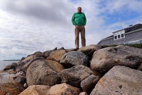 Chatham-09/20/18 Homeowner Gerald Milden is against the dredging in Chatham Harbor and says that it accelerates the loss of sand in front of his home, causing erosion. He stands near the huge boulders that were added to his oceanfront property after erosion from March storms nearly sank his home in the ocean. Photo by John Tlumacki/Globe Staff(metro) 
