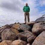 Gerald Milden is against the dredging in Chatham Harbor and said that it accelerated the loss of sand in front of his home, causing erosion. He stood near the huge boulders that were added to his oceanfront property.