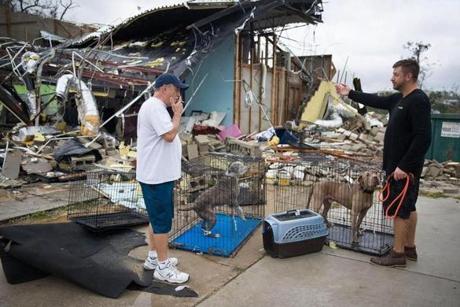 PANAMA CITY, FL - OCTOBER 10: Rick Teska (L) helps a business owner rescue his dogs from the damagd business after hurricane Michael passed through the area on October 10, 2018 in Panama City, Florida. The hurricane hit the Florida Panhandle as a category 4 storm. (Photo by Joe Raedle/Getty Images)

