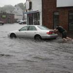 A man pushed his car in Quincy during a September flash flood last month. 