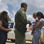 Two young mothers from Honduras and their children are detained by Border Patrol after rafting across the Rio Grande in Granjeno, Texas, in June. MUST CREDIT: Photo for The Washington Post by Jahi Chikwendiu