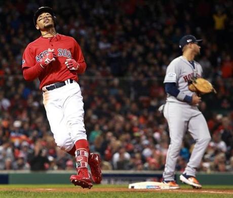 Boston, MA: 10-13-18: The Red Sox Mookie Betts (left) reacts after he grounded out to end the bottom of the third inning. Astros 1B Yuli Gurriel is at right. The Boston Red Sox hosted the Houston Astros in Game One of their ALCS baseball matchup at Fenway Park. (Jim Davis/Globe Staff) 
