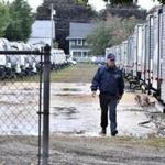 A Lawrence firefighter walked past a row of travel trailers Saturday.