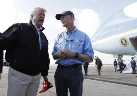 President Donald Trump speaks to the media with Florida Gov. Rick Scott, right, after arriving at Eglin Air Force Base to visit areas affected by Hurricane Michael, Monday, Oct. 15, 2018, at Eglin Air Force Base, Fla. (AP Photo/Evan Vucci)
