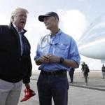 President Donald Trump speaks to the media with Florida Gov. Rick Scott, right, after arriving at Eglin Air Force Base to visit areas affected by Hurricane Michael, Monday, Oct. 15, 2018, at Eglin Air Force Base, Fla. (AP Photo/Evan Vucci)