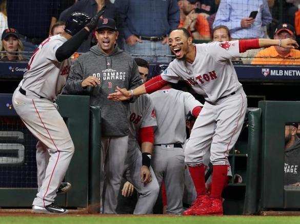 Houston, TX: 10-18-18: The Red Sox Rafael Devers gets the hero's welcome from manager Alex Cora and Mookie Betts following his sixth inning tree run home run that gave Boston a 4-0 lead. The Boston Red Sox visited the Houston Astros for Game Five of their ALCS baseball matchup at Minute Maid Park. (Jim Davis/Globe Staff) 
