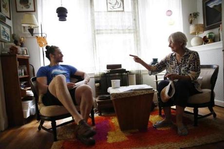 Cambridge, MA--8/23/2018-- Dean Kaplan (L) and Sarah Heintz chat together in the living room of the apartment they share in Cambridge. Heintz is renting out a room in her apartment to Kaplan through a new program called Nesterly that matches college students with senior citizens who have a room to rent out. The students get super cheap rent in exchange for helping out around the house and providing company for the elderly homeowner. (Jessica Rinaldi/Globe Staff) Topic: 31oddcouple Reporter: 
