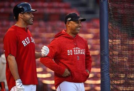 J.D. Martinez (left) has powered the offense, but Alex Cora is the single biggest influence on the Sox postseason performance.
