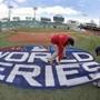Grounds crew members paint the World Series logo behind home plate at Fenway Park, Sunday, Oct. 21, 2018, in Boston as they prepare for Game 1 of the baseball World Series between the Boston Red Sox and the Los Angeles Dodgers scheduled for Tuesday. (AP Photo/Elise Amendola)