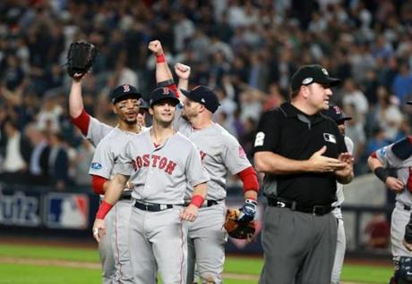 Mookie Betts, Andrew Benintendi and Steve Pearce are pictured celebrating Boston's series-clinching victory over the Yankees. 
