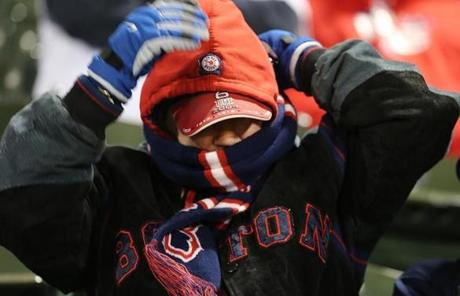 RED SOX SLIDER24 Boston, MA - 10/24/2018 - A fan tries to stay warm in the stands before Game 2 of the World Series. The Boston Red Sox host the Los Angeles Dodgers in Game 2 of the World Series at Fenway Park. (Stan Grossfeld/Globe staff)
