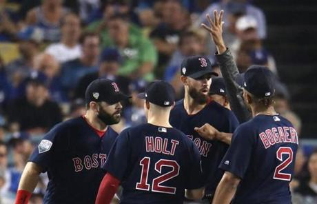 RED SOX SLIDER26 Los Angeles, CA - 10/26/2018 - Red Sox pitcher is surrounded by his teammates before being pulled from the game in the fifth inning. Los Angeles Dodgers hosted the Boston Red Sox in Game 3 of the World Series at Dodger Stadium. (Stan Grossfeld/Globe Staff)
