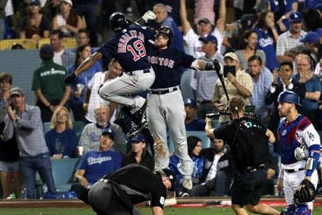 Los Angeles, CA - 10/26/2018 - (8th inning) Boston Red Sox center fielder Jackie Bradley Jr. (19) celebrates his game tying home run with catcher Chritian Vasquez in the eighth inning. The Los Angeles Dodgers host the Boston Red Sox in Game 3 of the World Series at Dodger Stadium. - (Barry Chin/Globe Staff), Section: Sports, Reporter: Peter Abraham, Topic: 27Dodgers-Red Sox, LOID: 8.4.3624881052.
