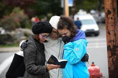PITTSBURGH, PA - OCTOBER 27:Tammy Hepps, Kate Rothstein and her daughter, Simone Rothstein, 16, pray from a prayerbook a block away from the site of a mass shooting at the Tree of Life Synagogue in the Squirrel Hill neighborhood on October 27, 2018 in Pittsburgh, Pennsylvania. (Photo by Jeff Swensen/Getty Images)
