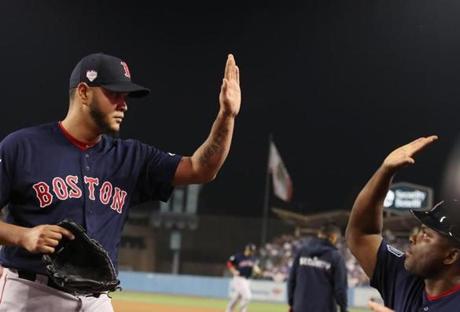 Los Angeles, CA - 10/26/2018 - Eduardo Rodriguez gets a high five from pitching coach Carlos Febles after he struck out last batter in the fifth inning in Game 3 of the World Series. The Los Angeles Dodgers host the Boston Red Sox in Game 3 of the World Series at Dodger Stadium. (Jim Davis/Globe staff)
