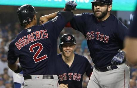 RED SOX SLIDER27 Los Angeles, CA - 10/27/2018 - Mitch Moreland celebrates with Xander Bogaerts and Brock Holt after hitting a three run home run in the seventh inning The Los Angeles Dodgers host the Boston Red Sox in Game 4 of the World Series at Dodger Stadium. (Jim Davis/Globe staff)
