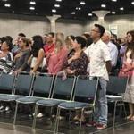 In this Sept. 18, 2018 photo new American citizens stand during a naturalization ceremony in Los Angeles. More than 700,000 immigrants are waiting on their applications to become U.S. citizens, a process that in many parts of the country now takes a year or more. The number of aspiring Americans surged during 2016, jumping 27 percent from a year ago as Donald Trump made cracking down on immigration a central point of his presidential campaign. (AP Photo/Amy Taxin)