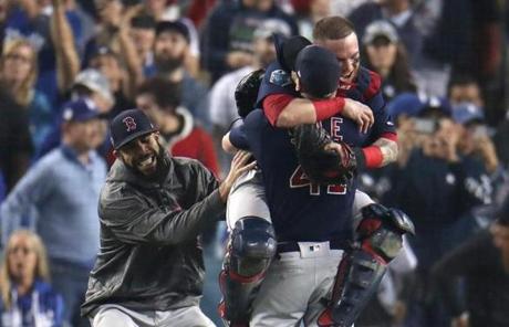 RED SOX SLIDER28 Los Angeles, CA - 10/28/2018 - Red Sox Christian Vazquez jumped onto Chris Sale after the Red Sox defeated the Dodgers 5-1. David Price (left) joined the celebration. Los Angeles Dodgers hosted the Boston Red Sox in Game 5 of the World Series at Dodger Stadium. (Stan Grossfeld/Globe Staff)
