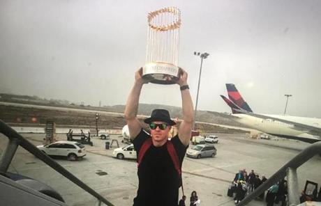 SLIDER --- California-- October 29, 2018--Red Sox Brock Holt hoisted the World Series championship trophy above his head before the teams flight back to Boston after defeating the Dodgers the night before. ( Stan Grossfeld/ Globe Staff)
