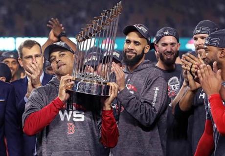 Los Angeles, CA: 10-28-18: Manager Alex Cora (left) hoists the trophy as (left to right) David Price, Rick Porcello, Chris Sale and Eduardo Nunez look on while the Red Sox celebrate their World Series victory. The Boston Red Sox visited the Los Angeles Dodgers in Game Five of the World Series at Dodger Stadium. (Jim Davis/Globe Staff)

